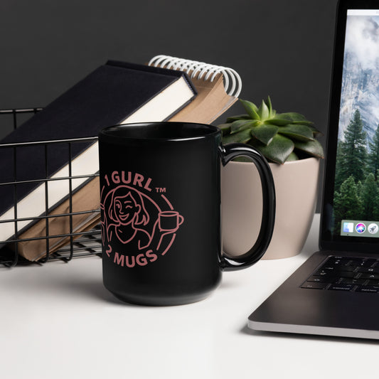 Black mug with pink logo on a desk with laptop and books